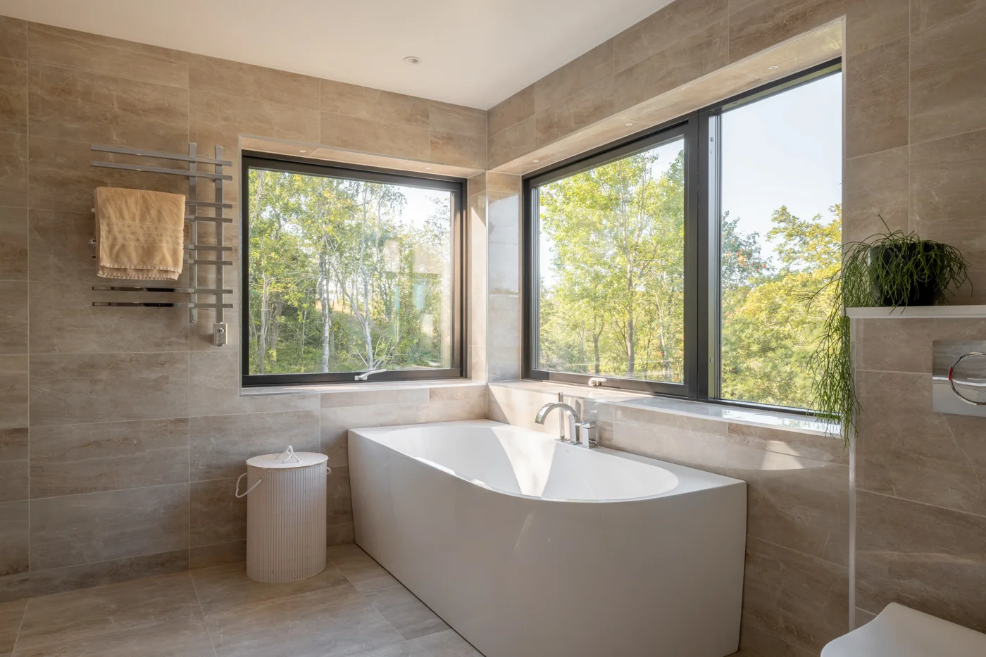 Badrum med fin vy mot grönska utanför - ritad av Innerstaden Arkitekter - fotograf Almeräng Fotografi